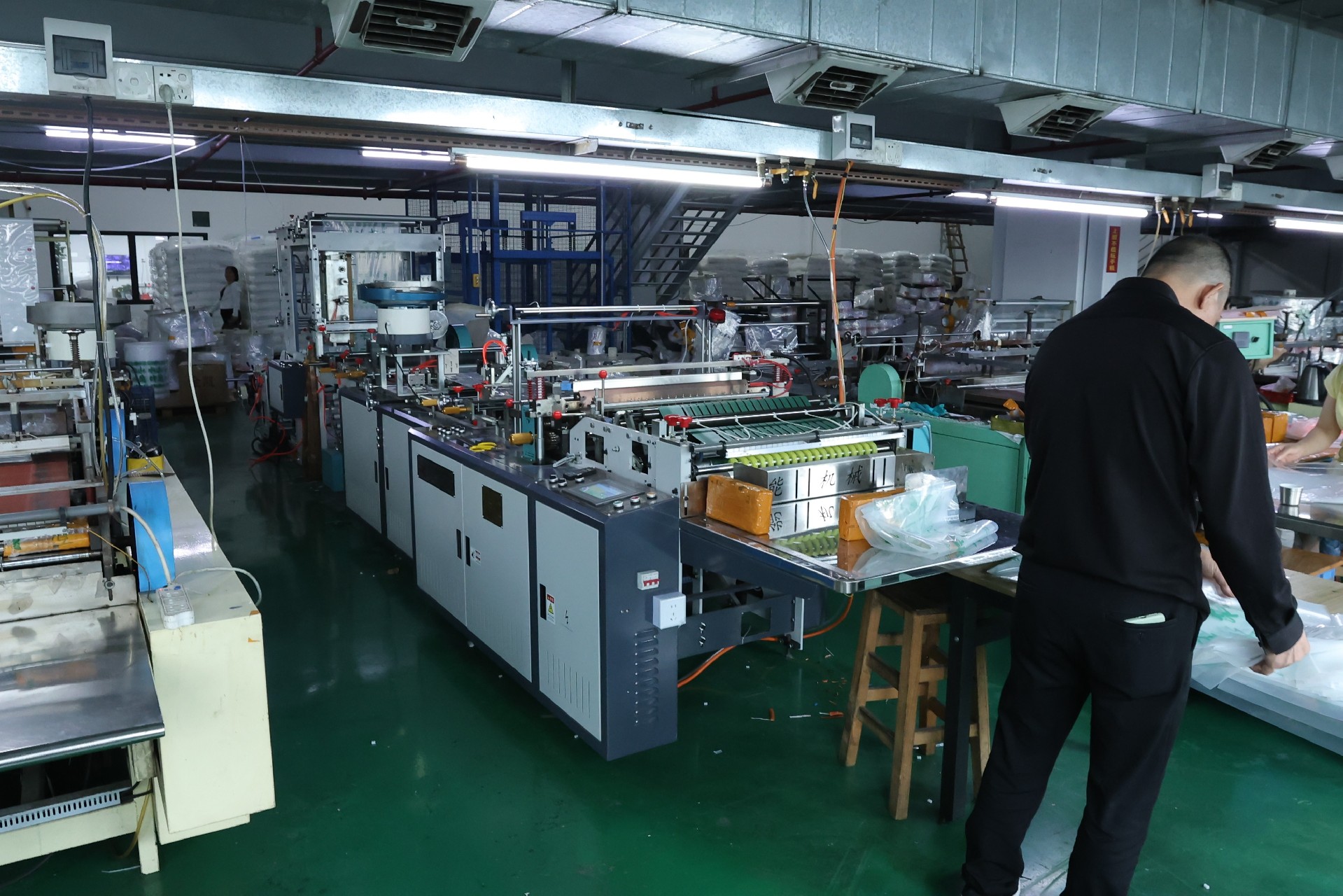 Bag-making machines producing resealable PE bags in a factory workshop